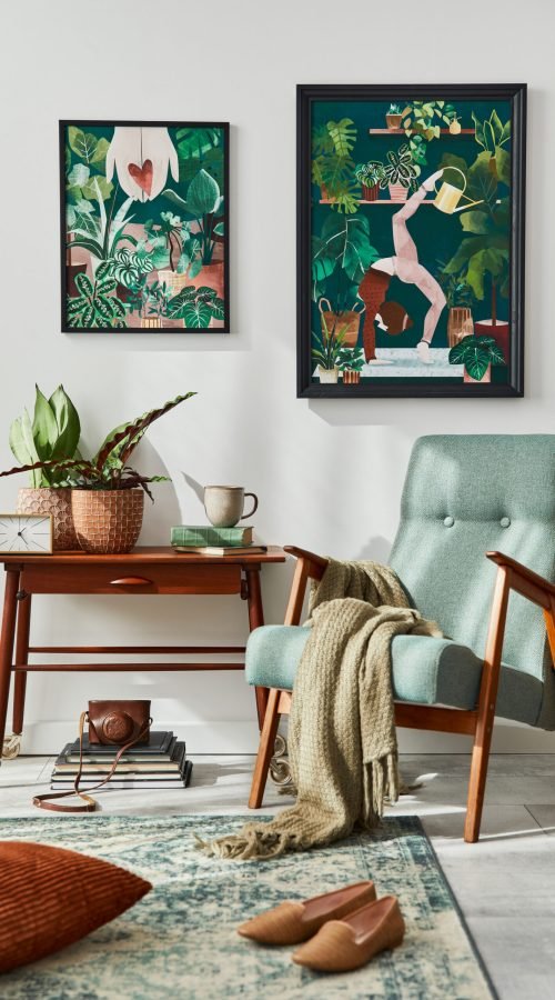 Interior design of retro living room with stylish vintage armchair, shelf, house plants, cacti, decoration, carpet and two mock up poster frames on the white wall. Botany home decor. Template.